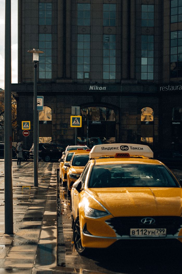 Crafting Captivating Headlines: Your awesome post title goes here Urban scene featuring parked yellow taxis on a city street in front of a building on a rainy day.